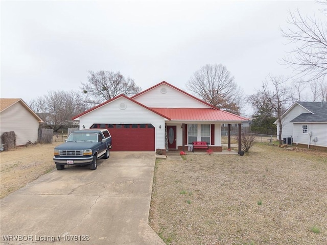 view of front facade with a garage, concrete driveway, metal roof, covered porch, and a front lawn