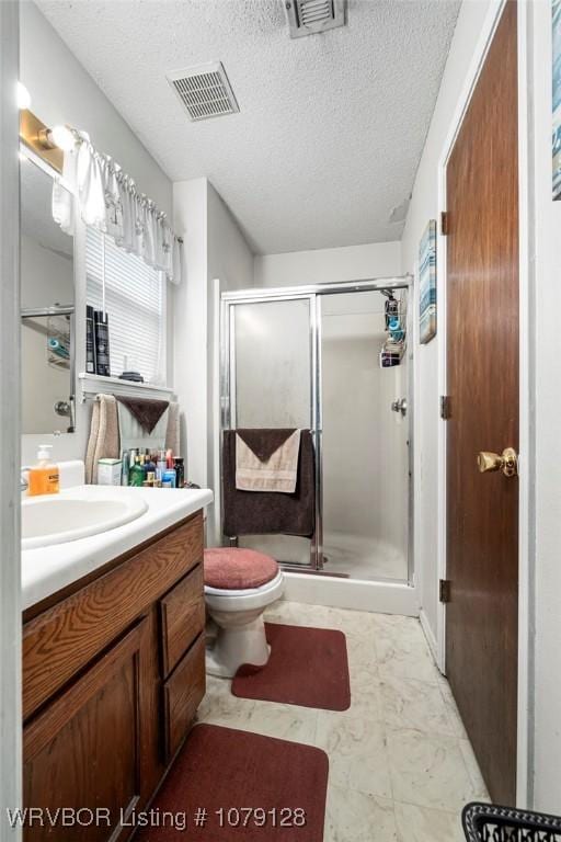 bathroom featuring a stall shower, visible vents, a textured ceiling, and vanity