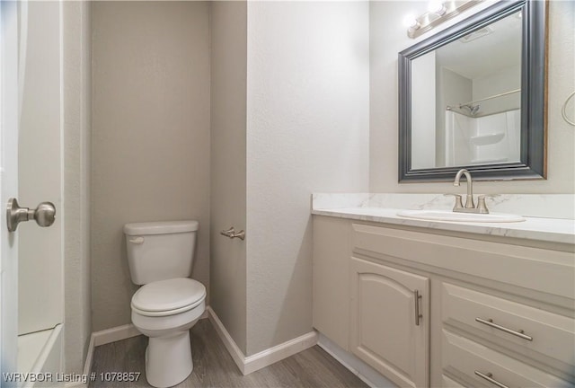 bathroom with hardwood / wood-style flooring, vanity, and toilet