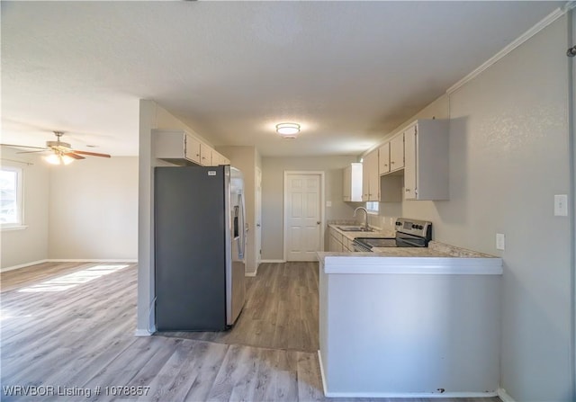 kitchen featuring sink, appliances with stainless steel finishes, kitchen peninsula, ceiling fan, and light hardwood / wood-style floors