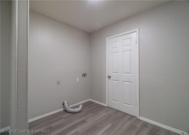 laundry room featuring electric dryer hookup and light hardwood / wood-style flooring