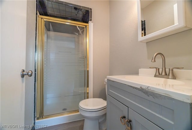 bathroom with walk in shower, vanity, and toilet