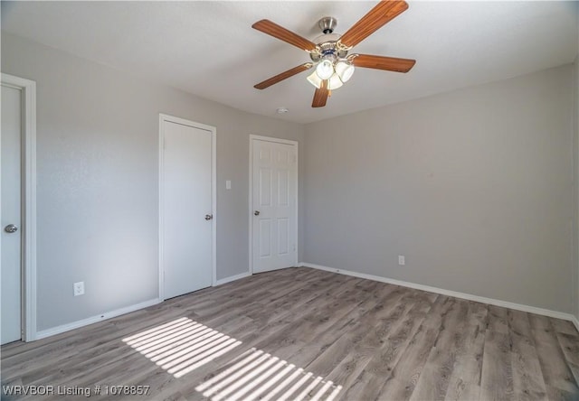 unfurnished room with ceiling fan and light wood-type flooring