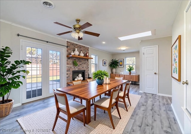 8915 Gary St, Fort Smith, AR 72903 - dining area featuring light wood-type flooring, ornamental molding, a ceiling fan, a skylight, and baseboards