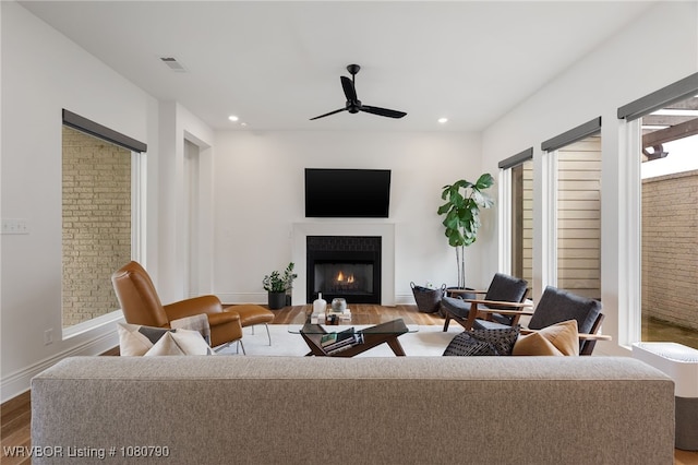 9101 Birkshire Pl, Fort Smith, AR 72916 - living area with baseboards, ceiling fan, visible vents, a lit fireplace, and wood finished floors