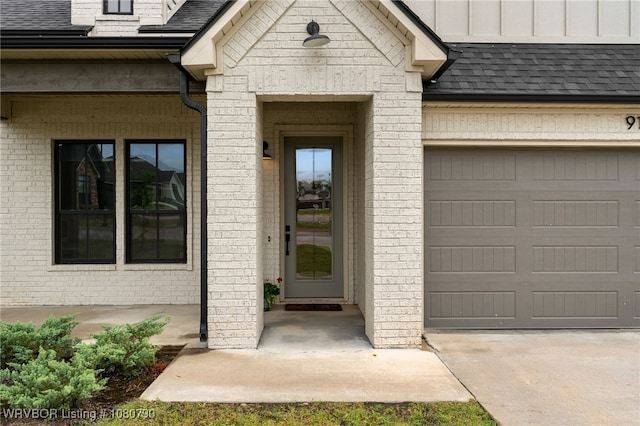 9101 Birkshire Pl, Fort Smith, AR 72916 - view of exterior entry featuring concrete driveway, brick siding, a shingled roof, and a garage