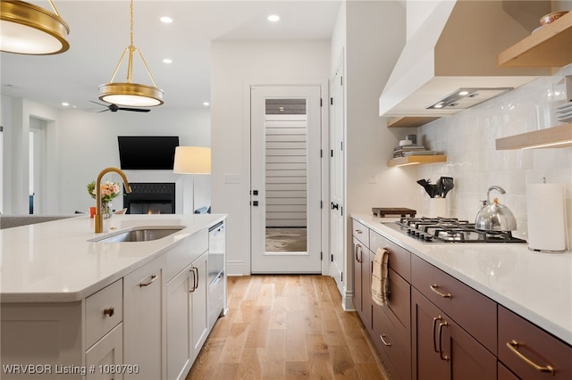 9101 Birkshire Pl, Fort Smith, AR 72916 - kitchen with a sink, stainless steel gas stovetop, open shelves, custom exhaust hood, and light wood-style flooring