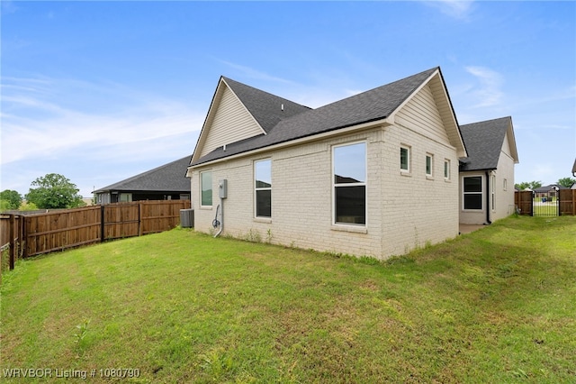 9101 Birkshire Pl, Fort Smith, AR 72916 - rear view of property featuring roof with shingles, brick siding, central AC, a yard, and a fenced backyard