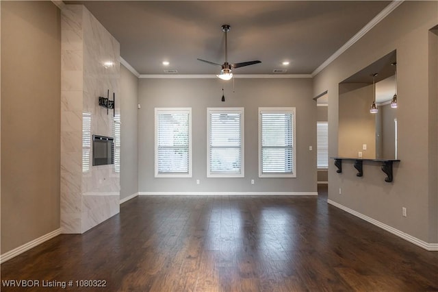 unfurnished living room featuring baseboards, ceiling fan, crown molding, a fireplace, and dark wood-type flooring
