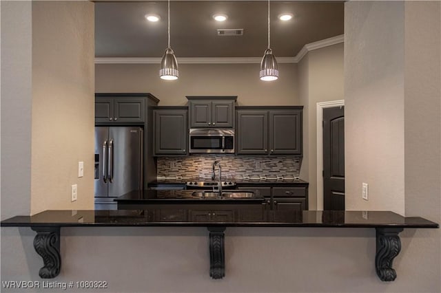 kitchen with stainless steel appliances, backsplash, visible vents, ornamental molding, and a sink
