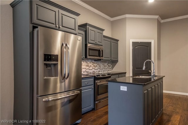 kitchen featuring stainless steel appliances, dark countertops, a sink, dark wood-type flooring, and gray cabinetry