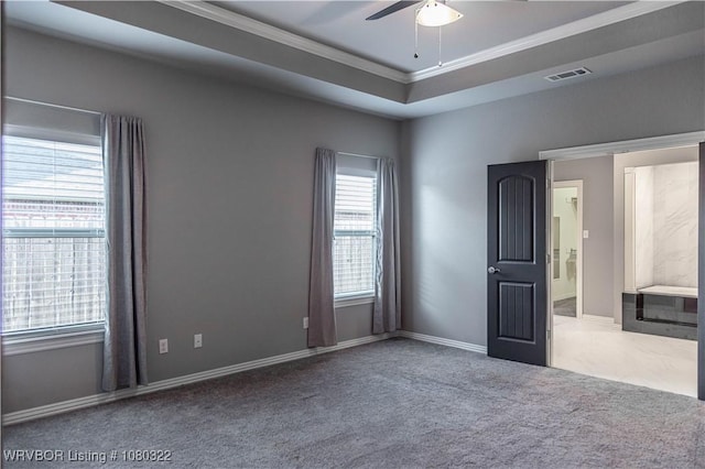 carpeted spare room with ceiling fan, visible vents, baseboards, and ornamental molding