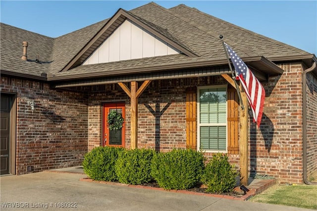 exterior space featuring brick siding and roof with shingles