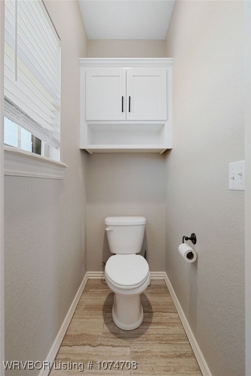 bathroom featuring hardwood / wood-style floors and toilet