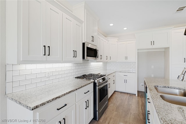 kitchen featuring white cabinetry, light stone countertops, sink, and stainless steel appliances