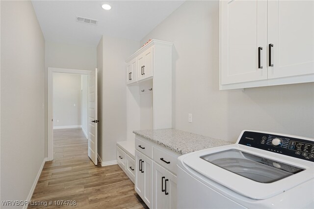 washroom featuring cabinets, washer / dryer, and light hardwood / wood-style flooring