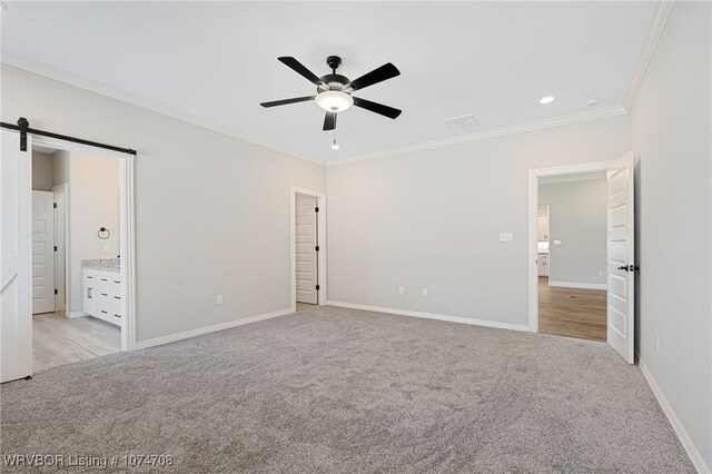 unfurnished bedroom with ensuite bathroom, ceiling fan, light carpet, and ornamental molding