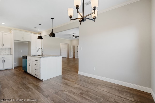 kitchen with ceiling fan with notable chandelier, a kitchen island with sink, sink, pendant lighting, and white cabinetry