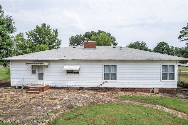 rear view of property featuring crawl space and a chimney