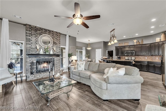 2601 Bugscuffle Rd, Lavaca, AR 72941 - living room featuring a ceiling fan, a fireplace, wood finished floors, and recessed lighting
