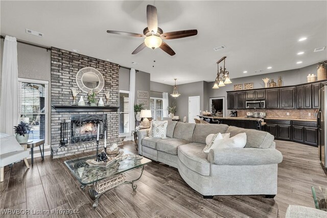 2601 Bugscuffle Rd, Lavaca, AR 72941 - living room featuring a ceiling fan, a fireplace, wood finished floors, and recessed lighting