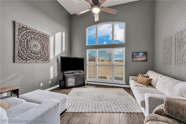 2601 Bugscuffle Rd, Lavaca, AR 72941 - living room featuring a ceiling fan, wood finished floors, a textured wall, and a towering ceiling
