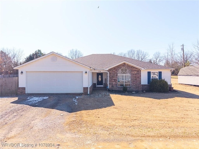 single story home featuring an attached garage, brick siding, fence, driveway, and roof with shingles