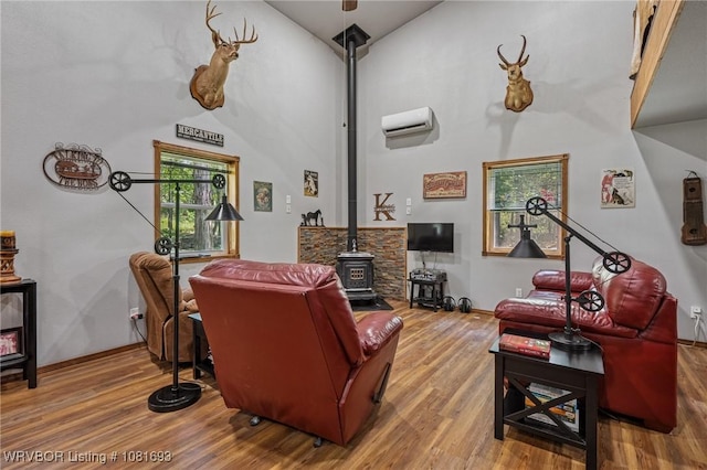 11667 Falling Rock Rd, Havana, AR 72842 - living area featuring a wood stove, wood finished floors, vaulted ceiling, and a wall mounted AC