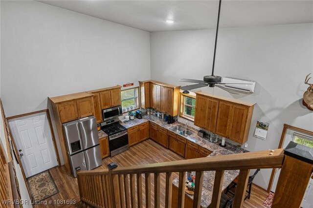 11667 Falling Rock Rd, Havana, AR 72842 - kitchen with stainless steel appliances, high vaulted ceiling, brown cabinetry, tasteful backsplash, and wood finished floors