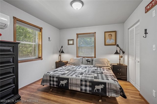 11667 Falling Rock Rd, Havana, AR 72842 - bedroom with multiple windows, a wall unit AC, and wood finished floors