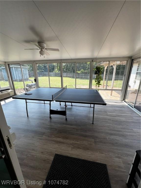 recreation room with expansive windows, ceiling fan, and dark wood-type flooring