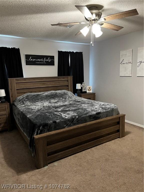 bedroom with ceiling fan, carpet, and a textured ceiling