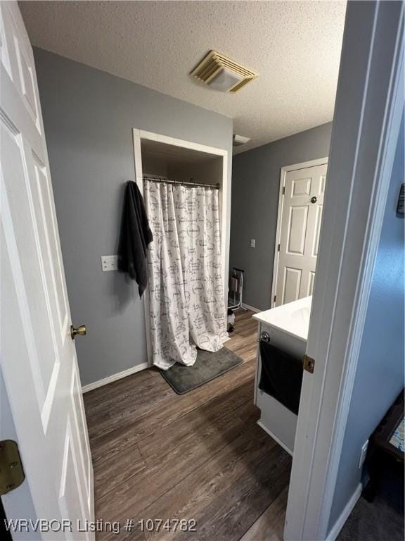 bathroom with vanity, a textured ceiling, and hardwood / wood-style flooring