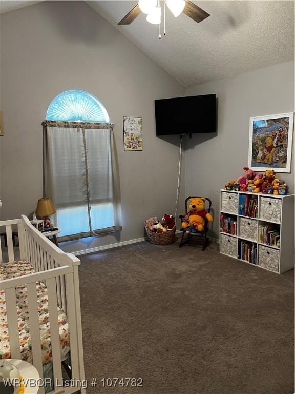 unfurnished bedroom featuring ceiling fan, dark colored carpet, lofted ceiling, a textured ceiling, and a crib