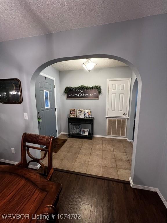 foyer featuring wood-type flooring and a textured ceiling