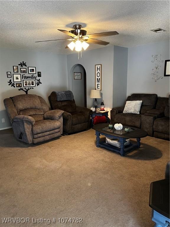 living room with carpet, a textured ceiling, and ceiling fan