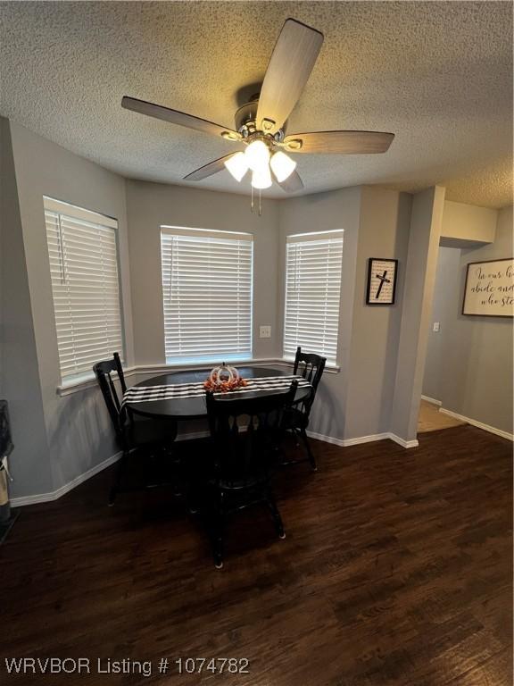 dining room featuring ceiling fan, dark hardwood / wood-style flooring, and a textured ceiling