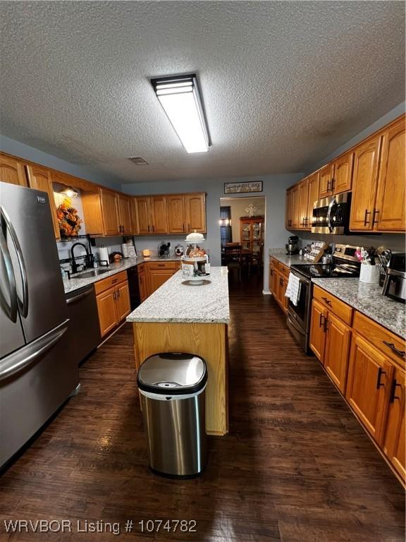 kitchen featuring a center island, dark hardwood / wood-style flooring, sink, and appliances with stainless steel finishes