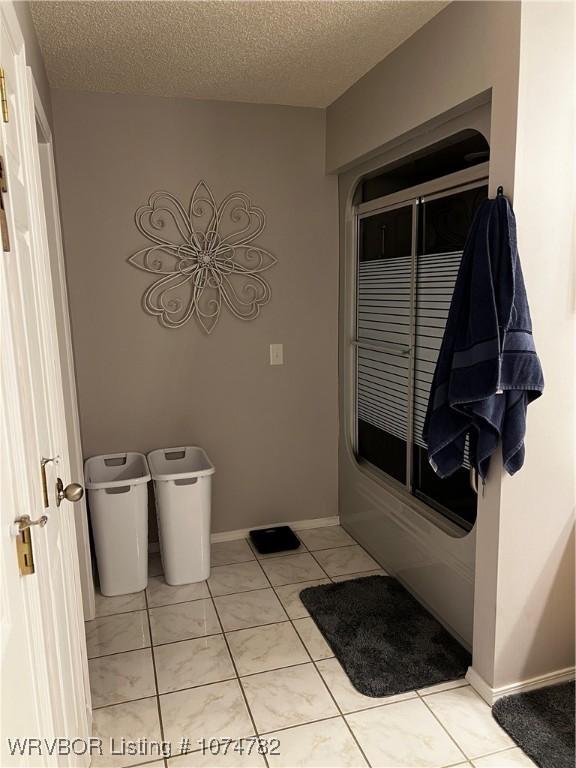 bathroom featuring tile patterned floors and a textured ceiling