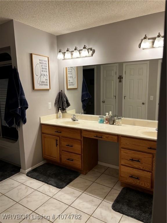 bathroom featuring vanity, a textured ceiling, and tile patterned floors