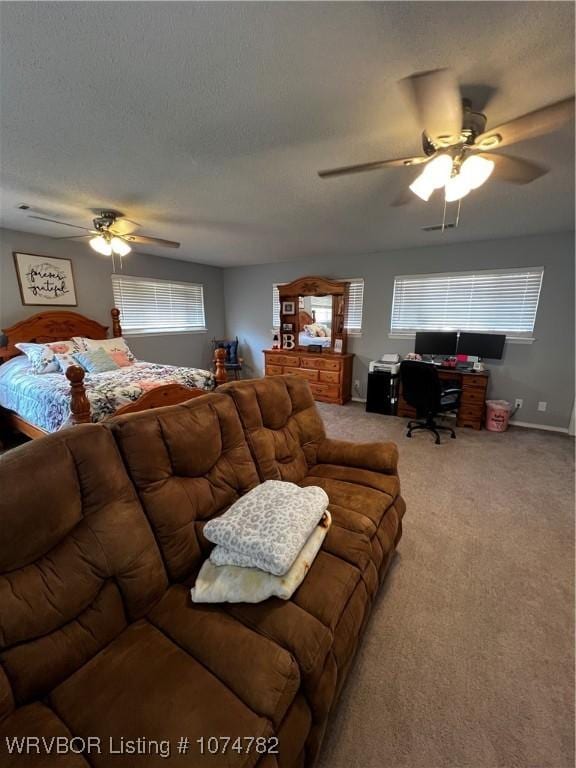 living room with ceiling fan, carpet floors, and a textured ceiling