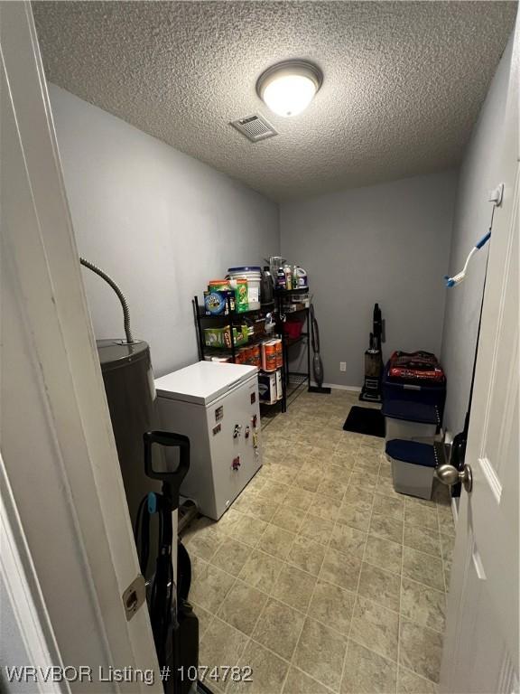 clothes washing area with a textured ceiling