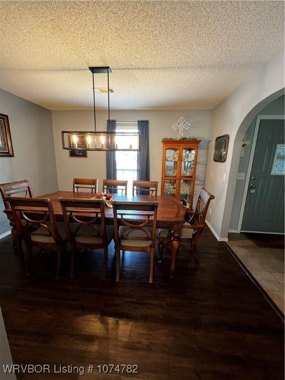 dining space featuring dark hardwood / wood-style flooring and a textured ceiling