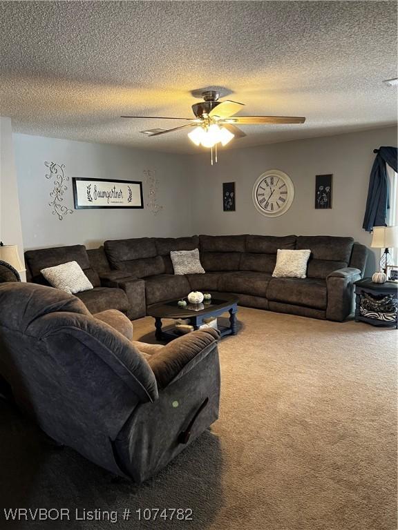 carpeted living room with a textured ceiling and ceiling fan