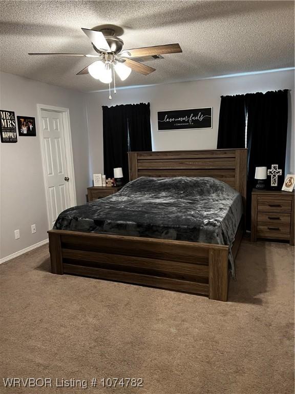 carpeted bedroom featuring ceiling fan and a textured ceiling