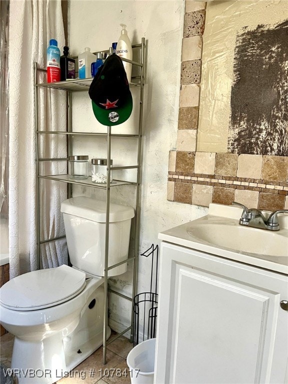 bathroom featuring tile patterned floors, toilet, vanity, and tasteful backsplash