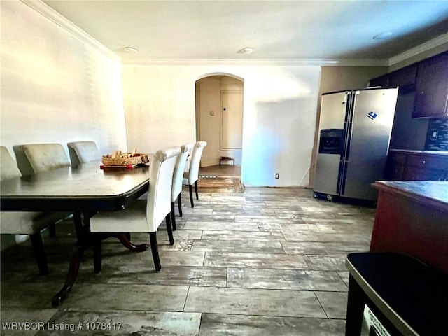 dining area featuring wood-type flooring and crown molding