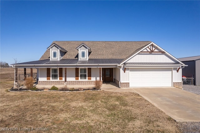 view of front of property featuring a garage, covered porch, and a front lawn