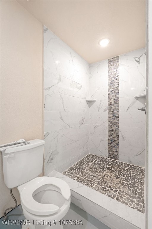 bathroom with tiled shower and toilet