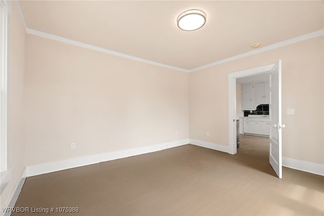 unfurnished room with crown molding and wood-type flooring